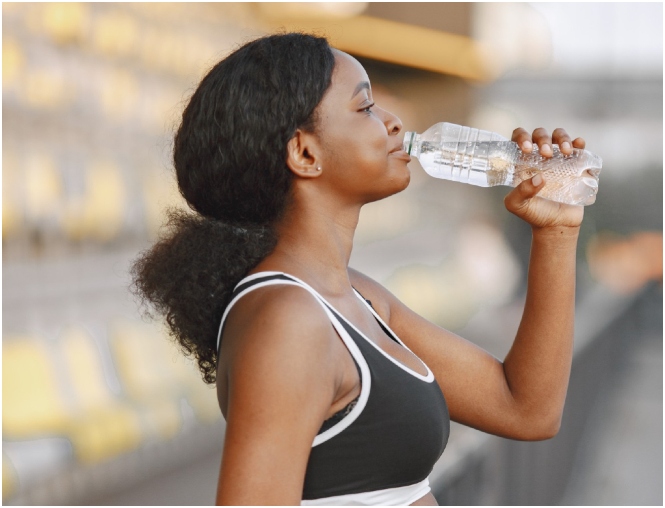 Fit woman drinking water