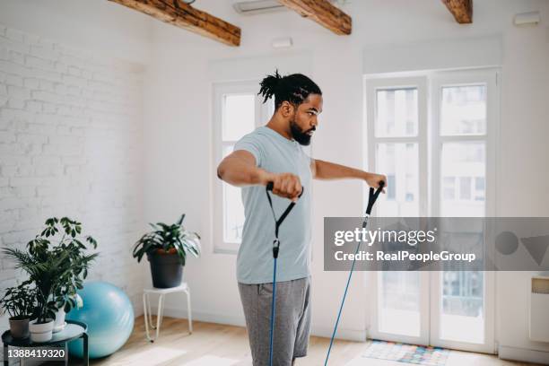 Man doing exercises with resistance bands at home.
